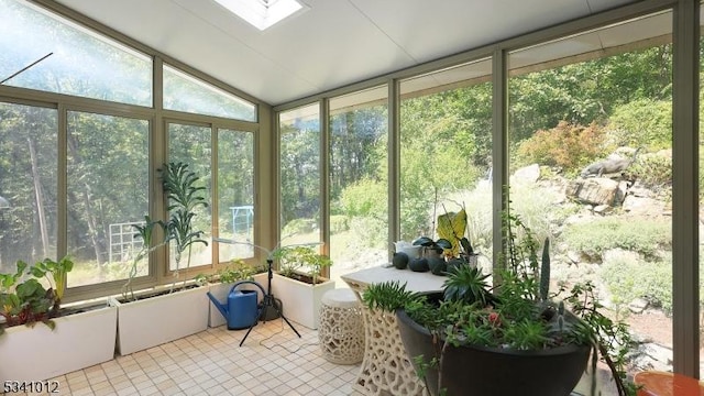 sunroom / solarium featuring vaulted ceiling with skylight