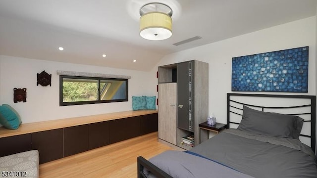 bedroom with lofted ceiling, light wood finished floors, visible vents, and recessed lighting