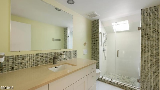 full bathroom featuring toilet, vanity, a shower stall, decorative backsplash, and tile patterned floors