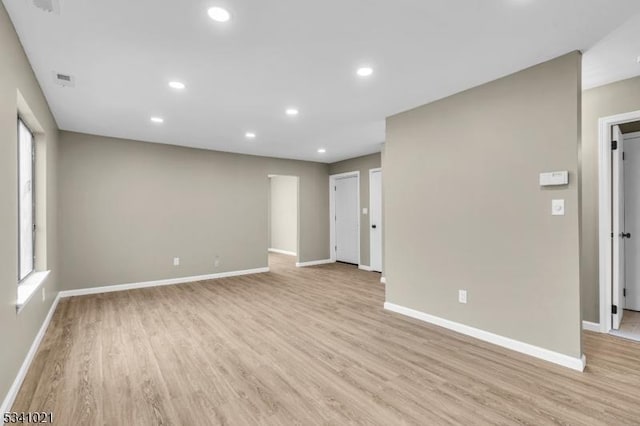 spare room featuring light wood-type flooring and baseboards