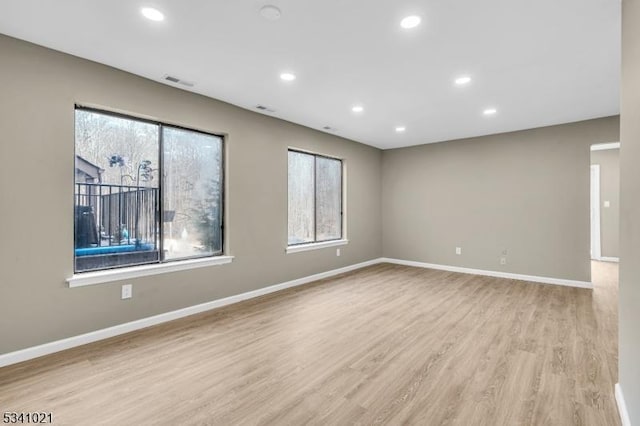 unfurnished room with recessed lighting, visible vents, baseboards, and wood finished floors