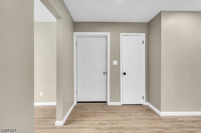 foyer with light wood finished floors and baseboards