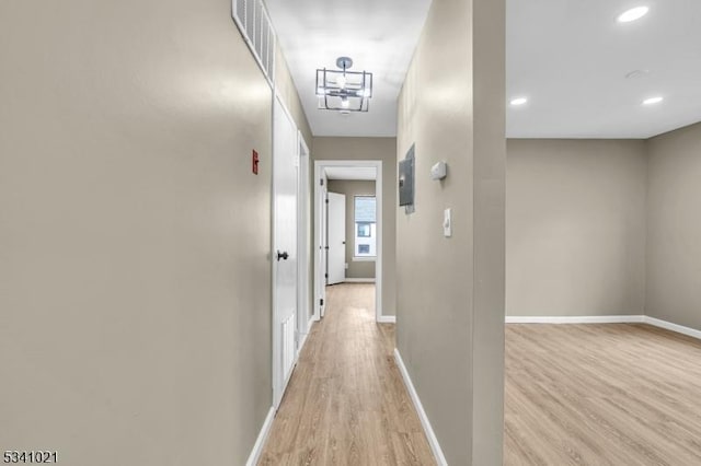 hall with light wood-style floors, visible vents, baseboards, and recessed lighting