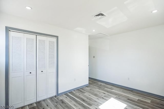 unfurnished bedroom featuring a closet, visible vents, light wood-style flooring, and recessed lighting