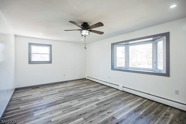 unfurnished room featuring wood finished floors, baseboards, a baseboard radiator, recessed lighting, and ceiling fan