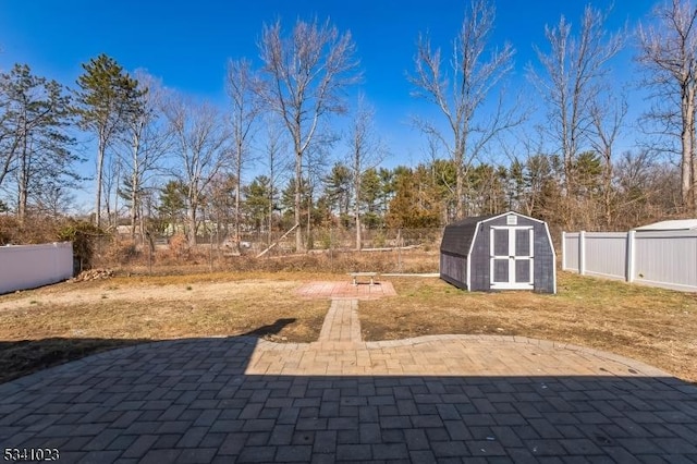 view of yard featuring a patio area, an outdoor structure, a storage shed, and a fenced backyard