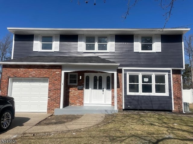 view of front of home with a porch, concrete driveway, a front yard, an attached garage, and brick siding