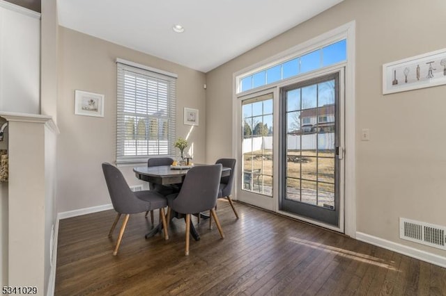 dining space featuring dark wood-type flooring, visible vents, and baseboards