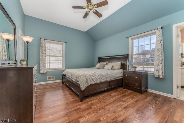 bedroom with multiple windows, vaulted ceiling, and wood finished floors