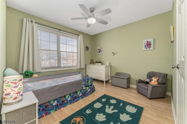 bedroom featuring a ceiling fan, baseboards, and wood finished floors