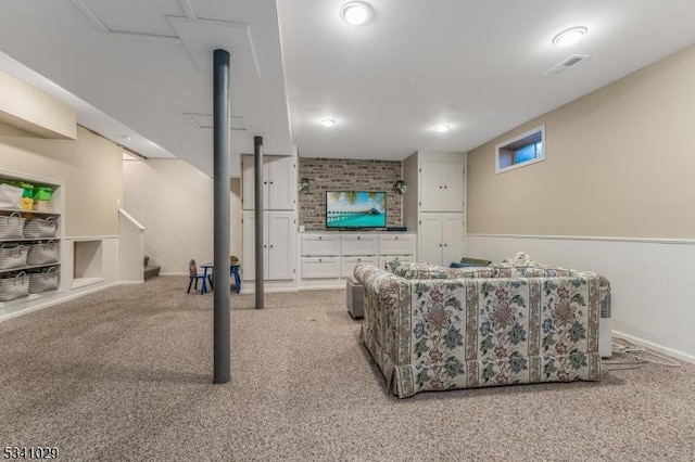 carpeted living room with visible vents and stairway