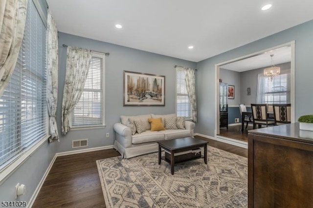 living area featuring a notable chandelier, recessed lighting, visible vents, wood finished floors, and baseboards