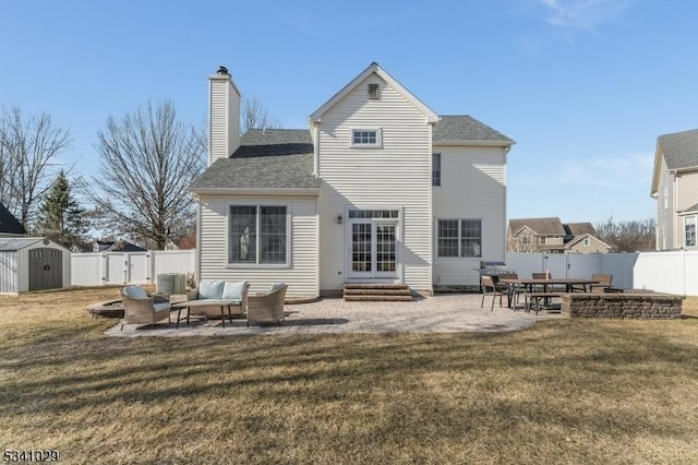 back of house with a yard, entry steps, a patio, and a storage unit