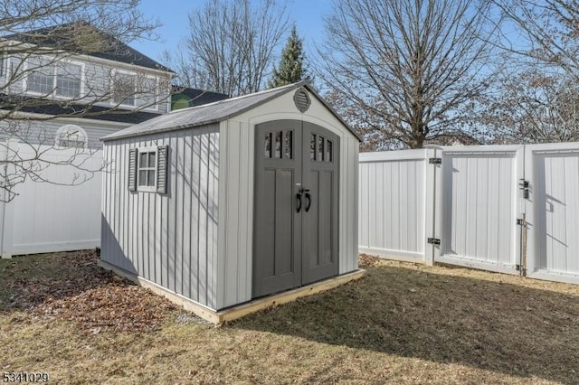 view of shed featuring a gate and fence