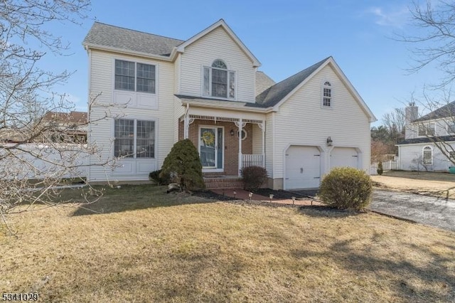 traditional-style house featuring covered porch, brick siding, a front lawn, and an attached garage