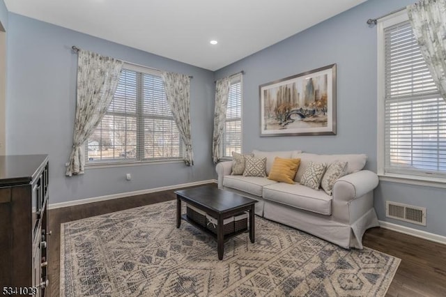 living area with baseboards, visible vents, wood finished floors, and recessed lighting