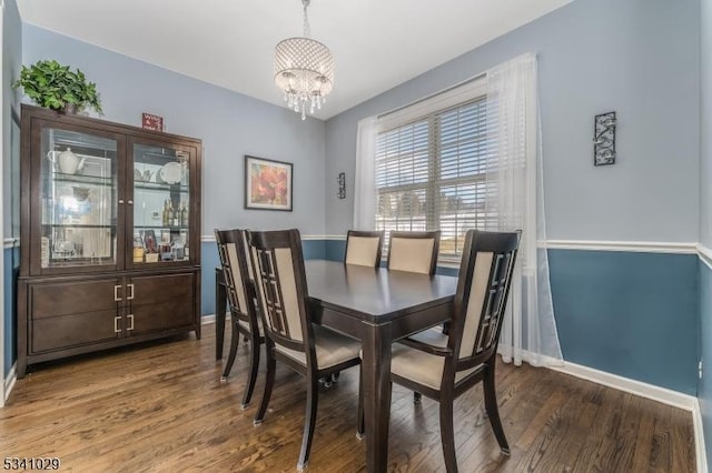 dining area with an inviting chandelier, baseboards, and wood finished floors