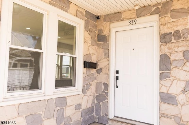 doorway to property featuring stone siding