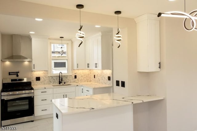 kitchen featuring light stone counters, white cabinetry, a sink, stainless steel gas range, and wall chimney exhaust hood