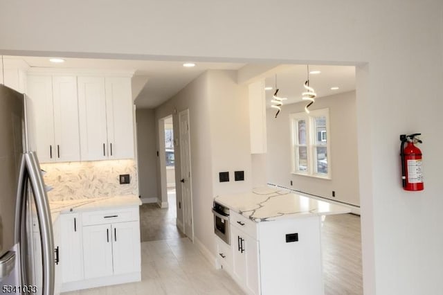 kitchen featuring recessed lighting, white cabinets, appliances with stainless steel finishes, backsplash, and light stone countertops