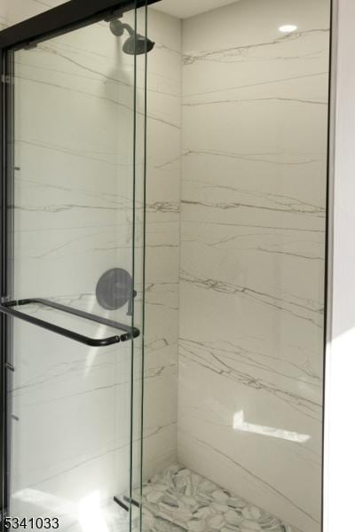 full bathroom featuring a marble finish shower