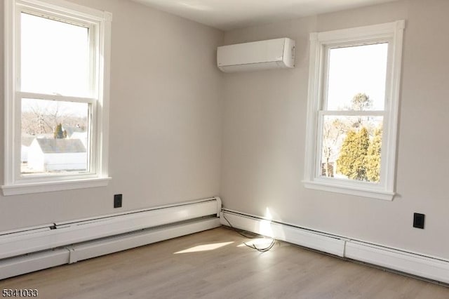 spare room with a wall unit AC, a baseboard radiator, a baseboard heating unit, and a wealth of natural light