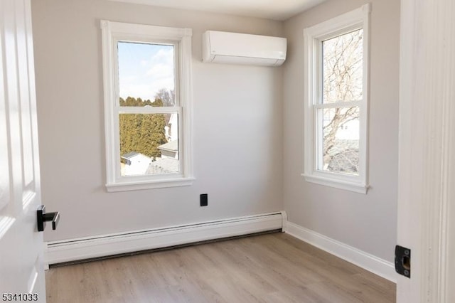 empty room featuring baseboard heating, a wall mounted AC, plenty of natural light, and baseboards