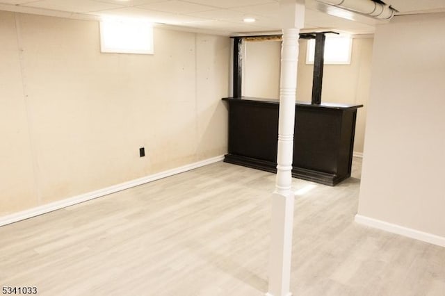 below grade area featuring a healthy amount of sunlight, baseboards, and wood finished floors