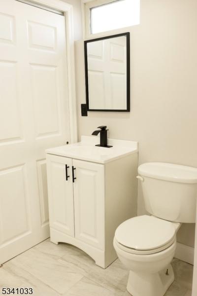 half bathroom with toilet and vanity