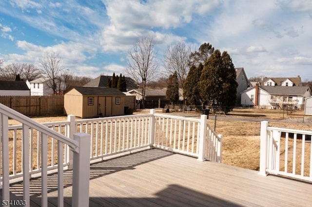 deck featuring a shed, a residential view, fence, and an outdoor structure