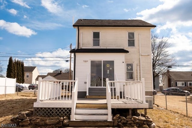 back of property with fence and a deck