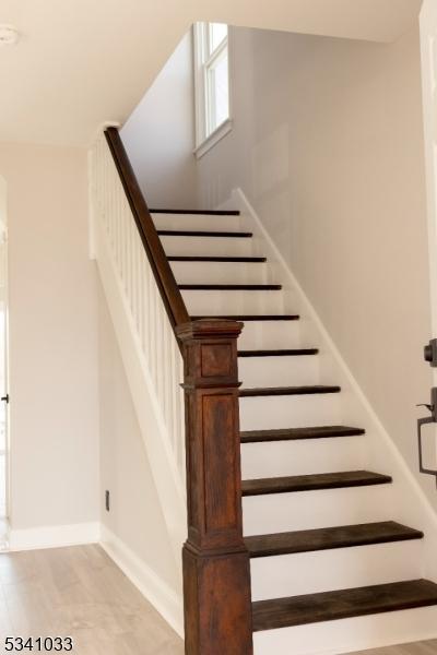 stairway with wood finished floors and baseboards