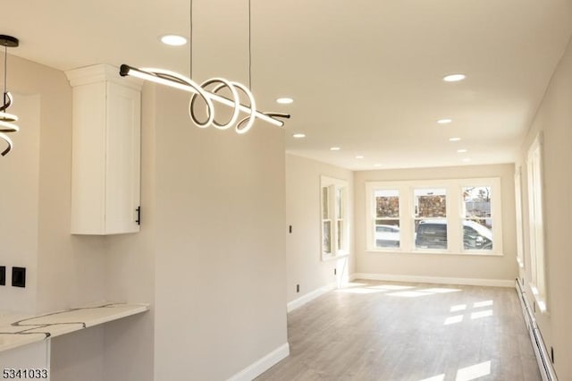 unfurnished dining area with a baseboard heating unit, a chandelier, and recessed lighting