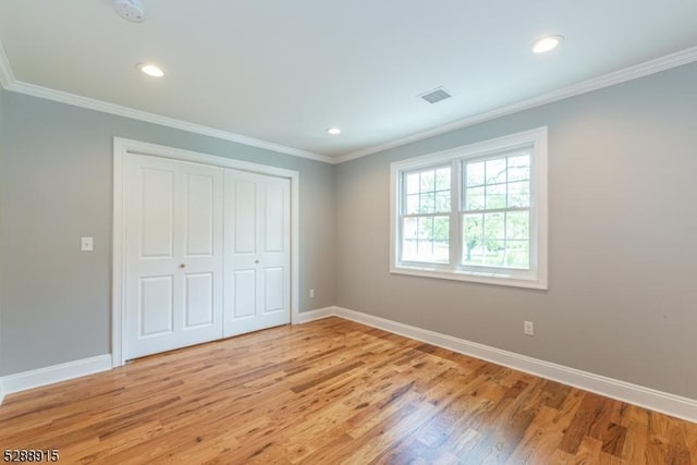 unfurnished bedroom with baseboards, light wood-style flooring, and crown molding