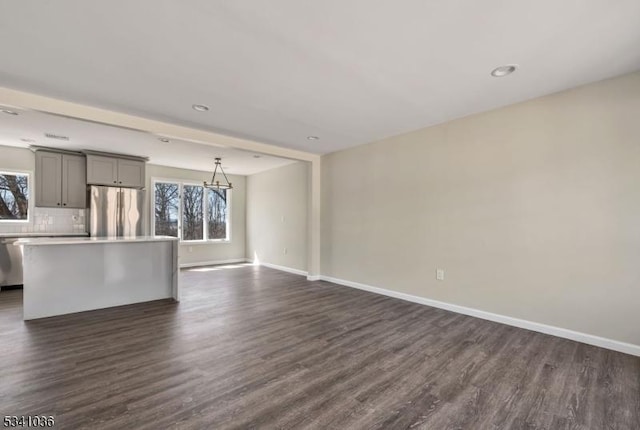 unfurnished living room featuring recessed lighting, dark wood-style floors, and baseboards