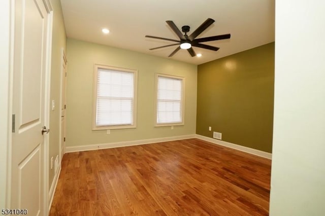 empty room with ceiling fan, recessed lighting, wood finished floors, visible vents, and baseboards