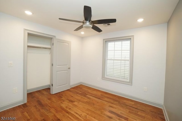 unfurnished bedroom featuring a closet, recessed lighting, wood finished floors, and baseboards