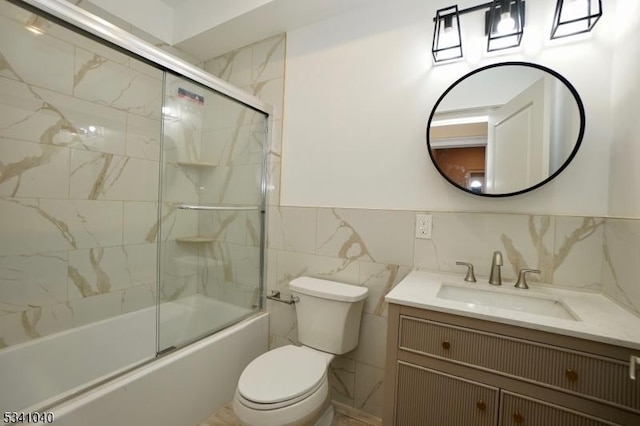 full bathroom featuring bath / shower combo with glass door, tile walls, toilet, and vanity