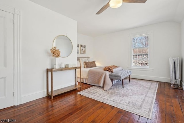 bedroom featuring hardwood / wood-style floors, radiator, a ceiling fan, and baseboards