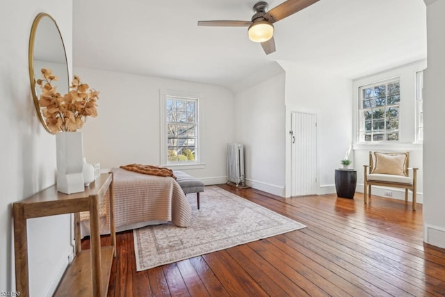 bedroom featuring radiator, a ceiling fan, baseboards, and hardwood / wood-style flooring