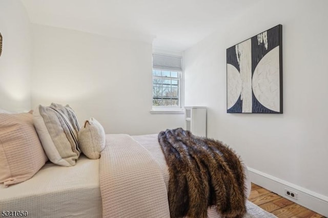 bedroom with baseboards and wood finished floors