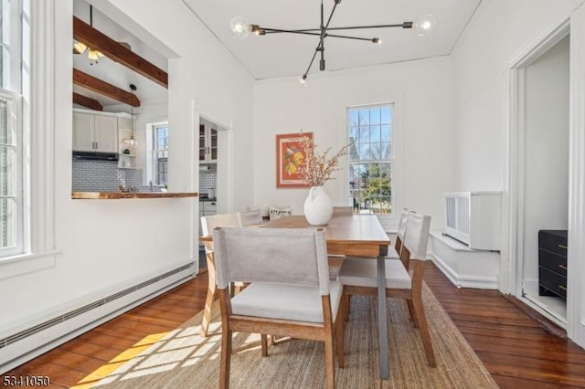 dining space with beam ceiling, wood finished floors, an inviting chandelier, and a baseboard radiator