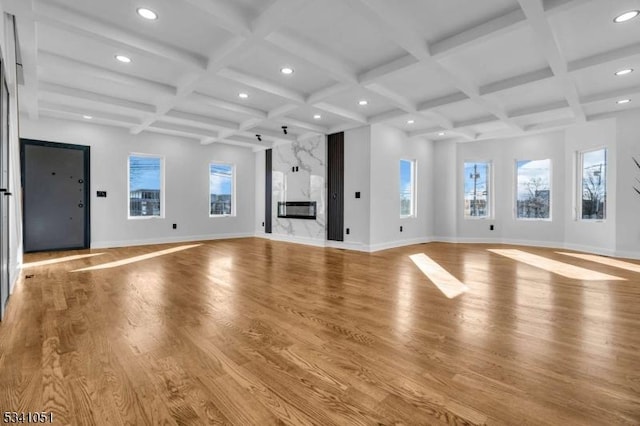 unfurnished living room featuring light wood-style flooring, baseboards, and a premium fireplace