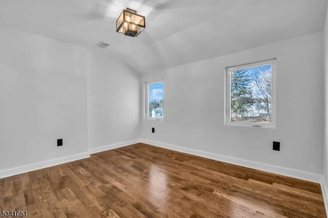 additional living space with a healthy amount of sunlight, baseboards, and wood finished floors