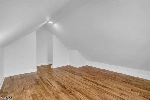 bonus room featuring recessed lighting, vaulted ceiling, baseboards, and wood finished floors