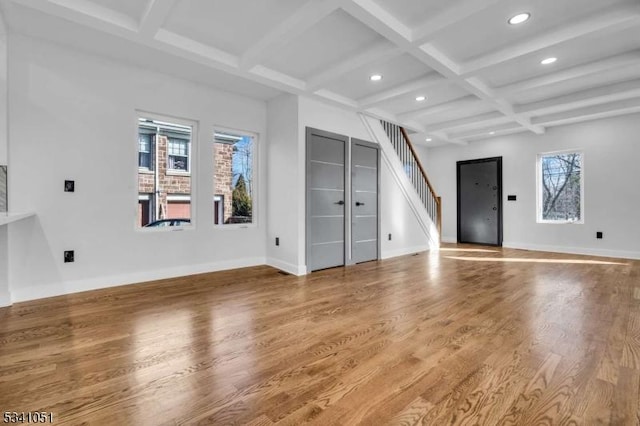 unfurnished living room with coffered ceiling, stairway, baseboards, and wood finished floors