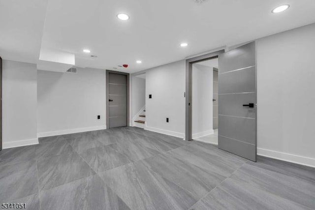 finished below grade area featuring stairs, recessed lighting, visible vents, and baseboards