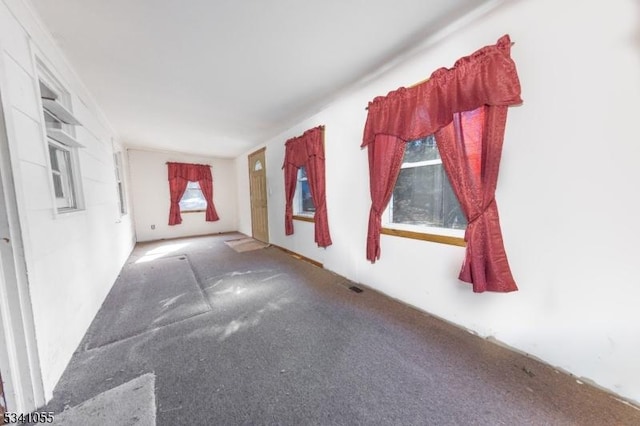 carpeted empty room featuring visible vents