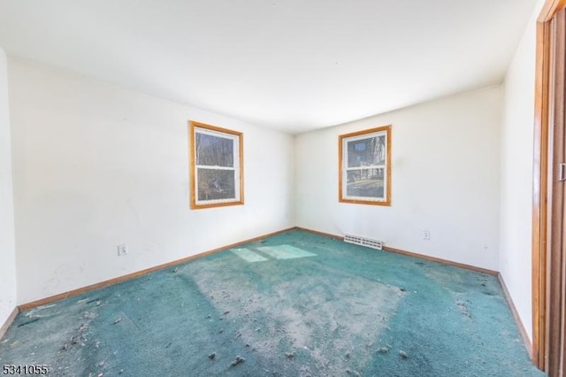 empty room with carpet, visible vents, and baseboards