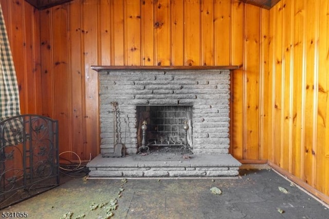 room details featuring wooden walls and a fireplace